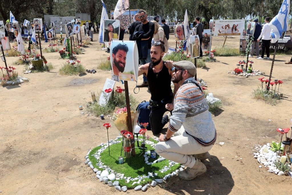 Los israelíes visitan un monumento con retratos de personas tomadas como rehenes o asesinadas en el ataque de Hamas al festival de música Supernova el 7 de octubre en el lugar del festival cerca del Kibbutz Reim en el sur de Israel el 10 de abril de 2024. (Foto de JACK GUEZ / AFP)