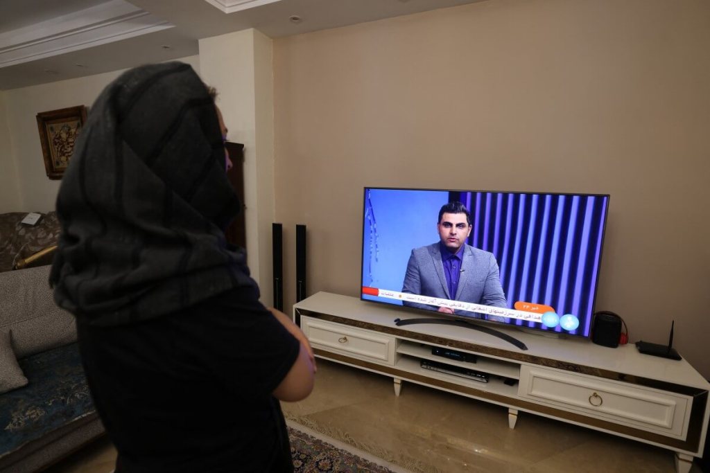 Una mujer iraní en Teherán mira un canal de televisión de noticias iraní, que cubre las noticias del ataque de Irán a Israel, el 14 de abril de 2024. Israel estaba siendo atacado directamente por Irán el sábado, anunció el ejército, en una importante escalada de la larga -Guerra encubierta entre enemigos regionales que amenazaba con eclipsar el conflicto en Gaza. (Foto de ATTA KENARE / AFP)CONTENIDO