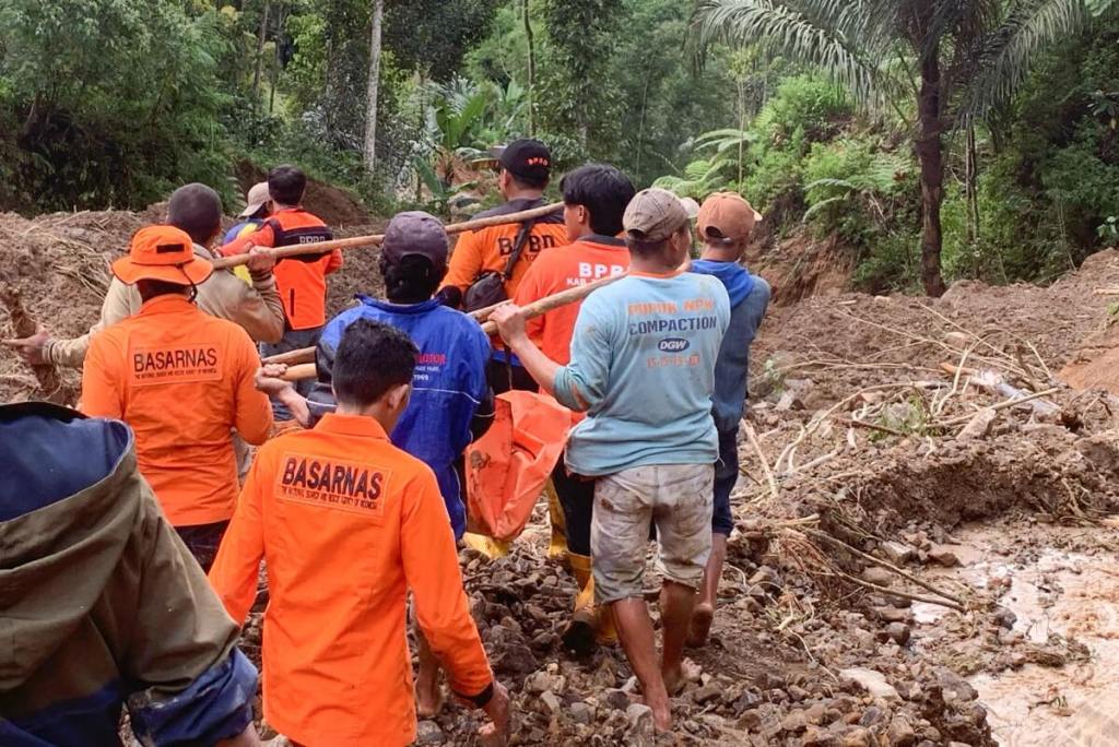 Esta fotografía publicada el 14 de abril de 2024 por la Agencia Nacional de Búsqueda y Rescate (BASARNAS) muestra a los rescatistas cargando una bolsa para cadáveres en el lugar de un deslizamiento de tierra en Tana Toraja, Sulawesi del Sur. (Foto de Handout / BASARNAS / AFP)