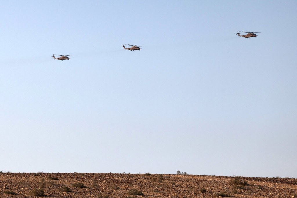 Helicópteros de transporte militar de carga pesada de la Fuerza Aérea de Israel sobrevuelan el sur del desierto de Negev el 14 de abril de 2024. (Foto de AHMAD GHARABLI / AFP)