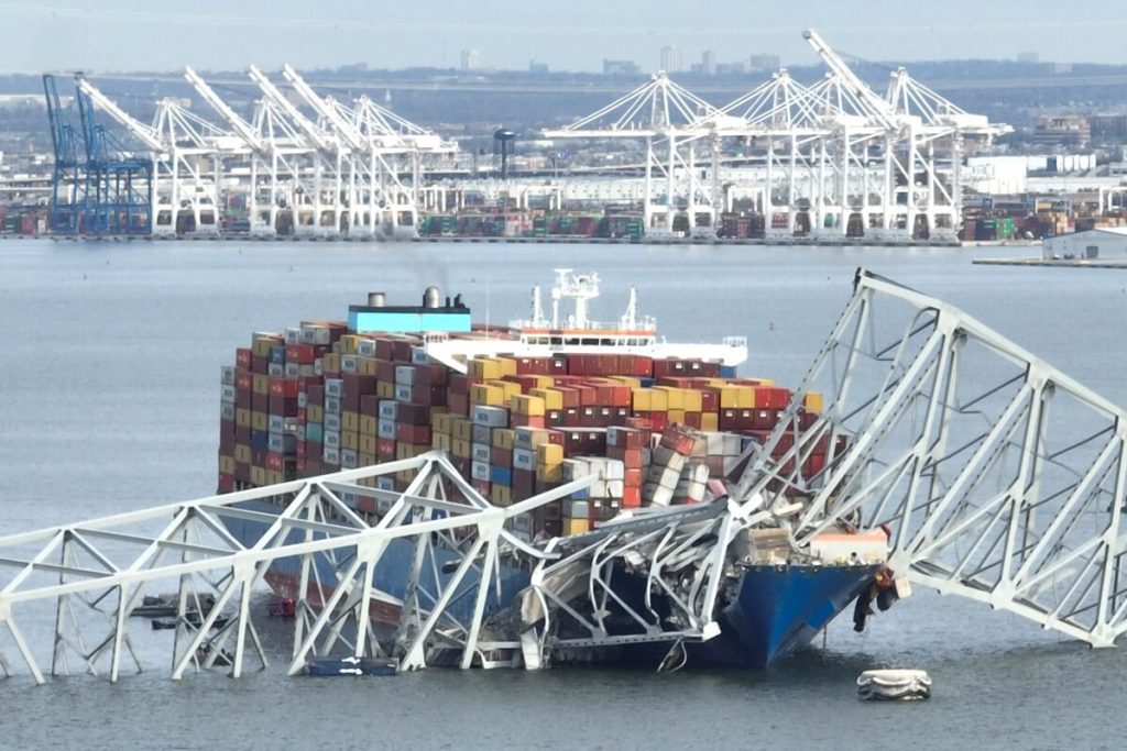 En esta imagen aérea, la estructura de acero del puente Francis Scott Key se encuentra encima de un buque portacontenedores después del colapso del puente, Baltimore, Maryland, el 26 de marzo de 2024. (Foto de Jim WATSON / AFP)
