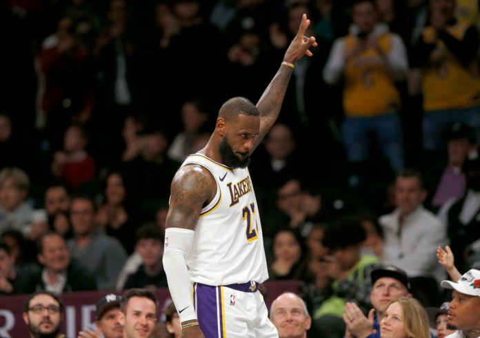 James recibe el reconocimiento de la fanaticada mientras se dirige al banquillo en los instantes finales del último período del juego de baloncesto ante los Nets de Brooklyn, el domingo 31 de marzo de 2024, en Nueva York. (AP Foto/John Munson)