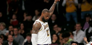 El alero de los Lakers de Los Ánngeles LeBron James recibe el reconocimiento de la fanaticada mientras se dirige al banquillo en los instantes finales del último período del juego de baloncesto ante los Nets de Brooklyn, el domingo 31 de marzo de 2024, en Nueva York. (AP Foto/John Munson)