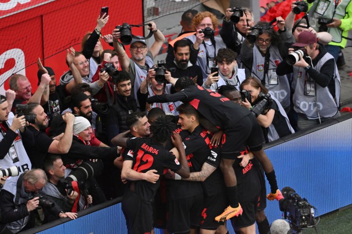 Jugadores del Bayer Leverkusen celebran tras el tercer gol de su equipo en el encuentro ante el Werder Bremen. El equipo confirmó el título de la Bundesliga con esta victoria el domingo 14 de abril del 2024. (David Inderlied/dpa via AP)