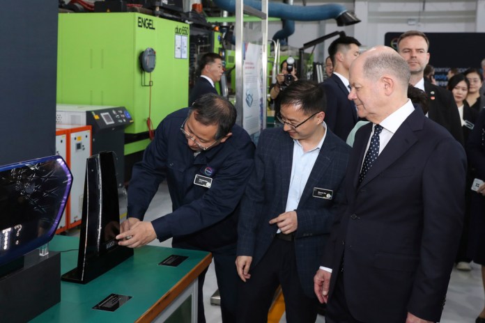 En esta imagen, distribuida por la agencia noticiosa Xinhua, el canciller de Alemania, Olaf Scholz (derecha), visita el Centro de Innovación Asia-Pacífico de la empresa alemana Covestro en Shanghái, el 15 de abril de 2024. (Fang Zhe/Xinhua vía AP)