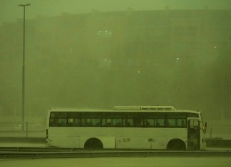 Un autobús abandonado bajo una lluvia mientras el cielo se volvía verde en Dubái. (Foto AP/Jon Gambrell)