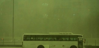 Un autobús abandonado bajo una lluvia mientras el cielo se volvía verde en Dubái. (Foto AP/Jon Gambrell)