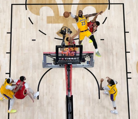 LeBron James (23), dispara entre el base de los New Orleans Pelicans, Trey Murphy III, y el base CJ McCollum en la segunda mitad de un partido del torneo de baloncesto de la NBA el martes 16 de abril de 2024 en Nueva Orleans. Los Lakers ganaron 110-106. (Foto AP/Gerald Herbert)