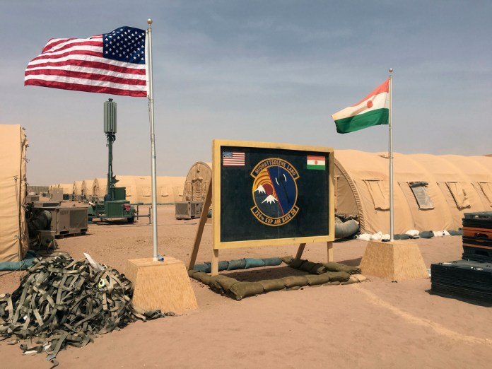 ARCHIVO - Banderas de Níger y Estados Unidos ondean en el campamento base para miembros de la fuerza aérea y otro personal que ayuda en la construcción de la Base Aérea 201 de Níger, el 16 de abril de 2018, en Agadez, Níger. (AP Foto/Carley Petesch, Archivo)