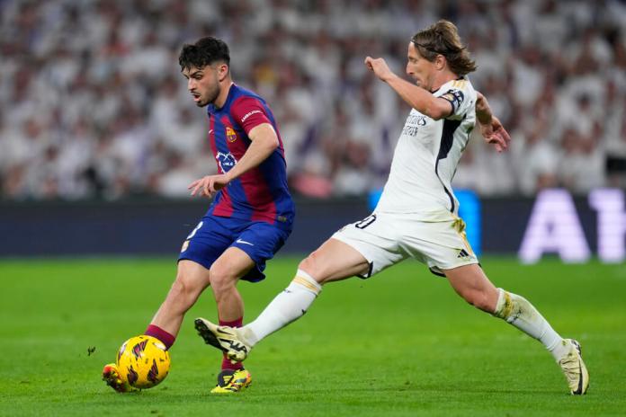 edri del Barcelona, izquierda, es desafiado por Luka Modric del Real Madrid durante el partido de fútbol de la Liga española. (Foto AP/Manu Fernández)