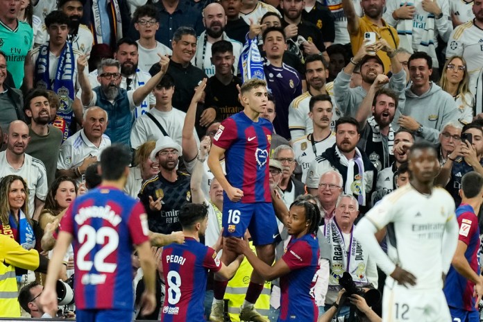 Fermín López del Barcelona celebra tras anotar el segundo gol de su equipo durante el partido de fútbol de la Liga española entre Real Madrid y Barcelona en el estadio Santiago Bernabéu de Madrid, España, el domingo 21 de abril de 2024. (Foto AP/José Bretón)