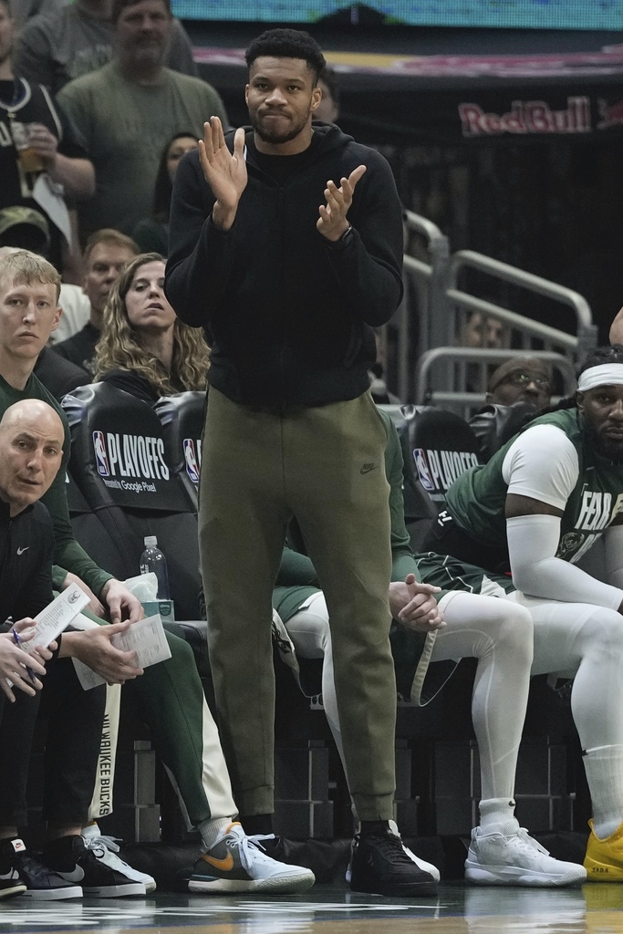 Giannis Antetokounmpo, de los Milwaukee Bucks, observa desde el banco durante la primera mitad del Juego 1 del partido de baloncesto de playoffs de la NBA el domingo 21 de abril de 2024 en Milwaukee. (Foto AP/Morry Gash)