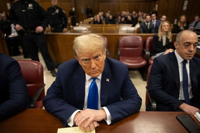 El expresidente Donald Trump, en el centro, espera el inicio del procedimiento en el tribunal penal de Manhattan. (Foto AP/Yuki Iwamura, Pool)