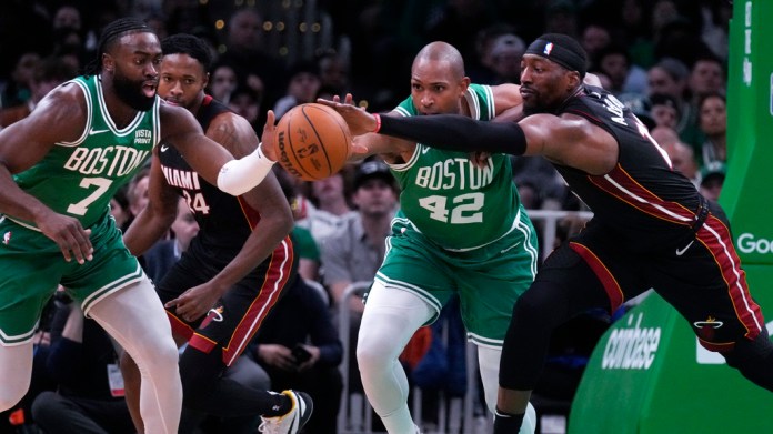 El pívot de los Miami Heat, Bam Adebayo, derecha, lucha por el balón contra el pívot de los Boston Celtics,24 de abril de 2024, en Boston. (Foto AP/Charles Krupa)