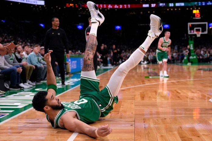 El delantero de los Boston Celtics, Jayson Tatum, cae al suelo después de un tiro contra el Miami Heat en Boston. (Foto AP/Charles Krupa)