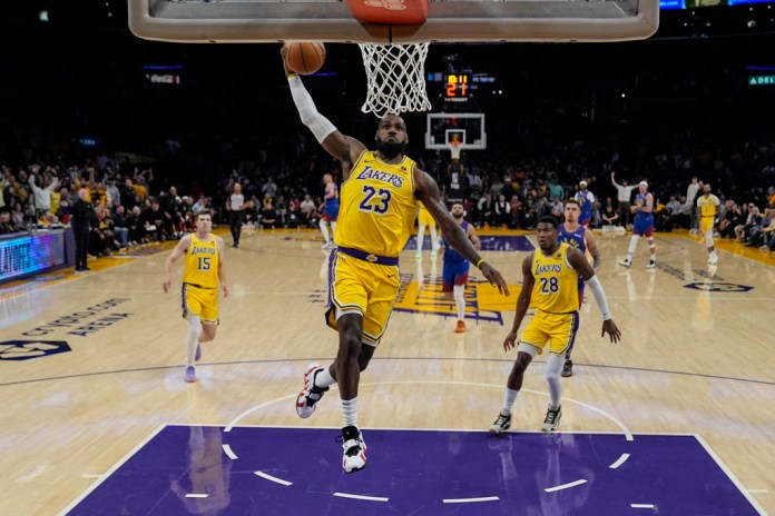 El alero de Los Angeles Lakers, LeBron James (23), hace mates durante la primera mitad del tercer juego de una serie de playoffs de primera ronda de baloncesto de la NBA contra los Denver Nuggets en Los Ángeles, el jueves 25 de abril de 2024. (Foto AP/Ashley Landis)