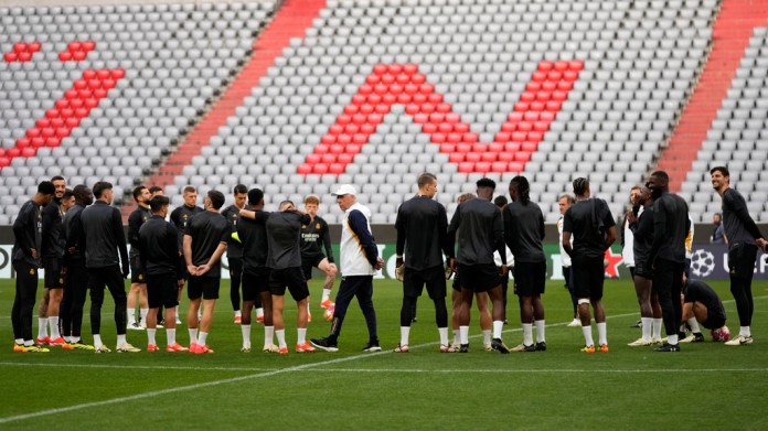 Real Madrid coach Carlo Ancelotti, center, is surrounded by his players before a training session in Munich, Germany, Monday, April 29, 2024, ahead of the first leg of their Liga de la Liga semifinal. Champions between FC Bayern Munich and Real Madrid.  (AP Photo/Matthias Schrader)