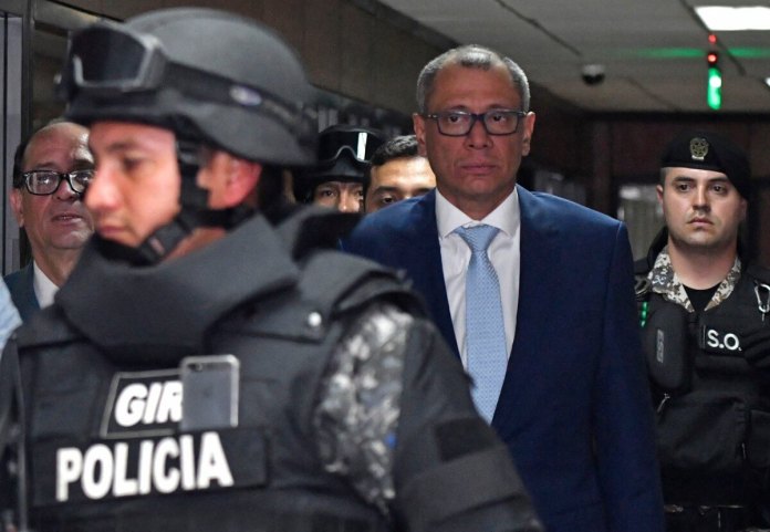 El vicepresidente ecuatoriano, Jorge Glas (centro), es acompañado de regreso a la sala del tribunal junto a su abogado Eduardo Franco Loor. (Foto de Juan Ruiz/AFP)