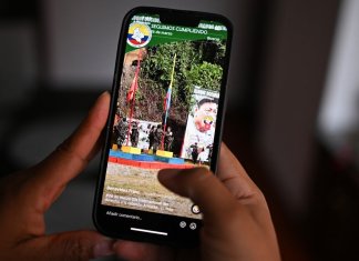 Esta ilustración muestra a una mujer mirando una cuenta de Tik Tok del Frente Franco Benavides de la guerrilla disidente de las FARC en Bogotá el 2 de abril de 2024. (Foto de Luis ACOSTA/AFP)