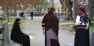 Varias personas hablan con la policía luego de que se registró un tiroteo durante un evento de la festividad musulmana de Eid al-Fitr, el miércoles 10 de abril de 2024, en Filadelfia. (Monica Herndon/The Philadelphia Inquirer vía AP)
