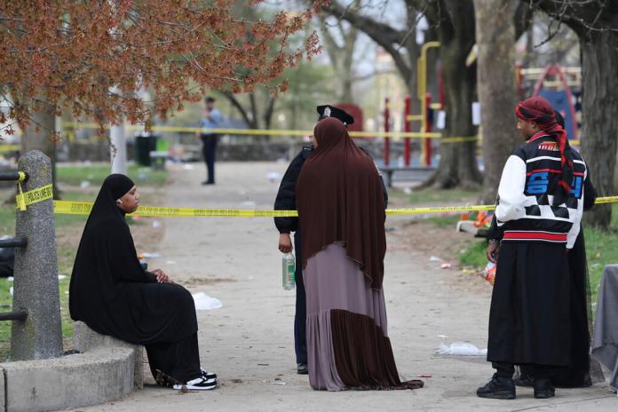 Varias personas hablan con la policía luego de que se registró un tiroteo durante un evento de la festividad musulmana de Eid al-Fitr, el miércoles 10 de abril de 2024, en Filadelfia. (Monica Herndon/The Philadelphia Inquirer vía AP)