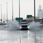 Una camioneta arroja agua a su paso por una carretera anegada, con el edificio Burj Al Arab, de fondo, en Dubái, Emiratos Árabes Unidos, el 16 de abril de 2024. (AP Foto/Jon Gambrell)