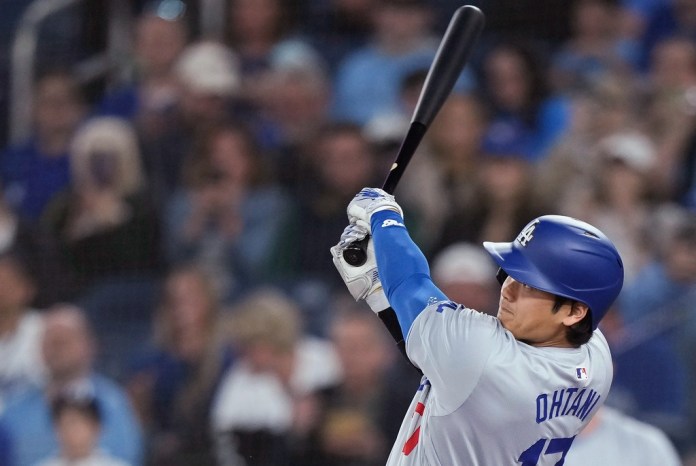 El bateador designado de los Dodgers de Los Ángeles Shohei Ohtani observa su jonrón solitario en la primera entrada del juego ante los Azulejos de Toronto el viernes 26 de abril del 2024. (Nathan Denette/The Canadian Press via AP)