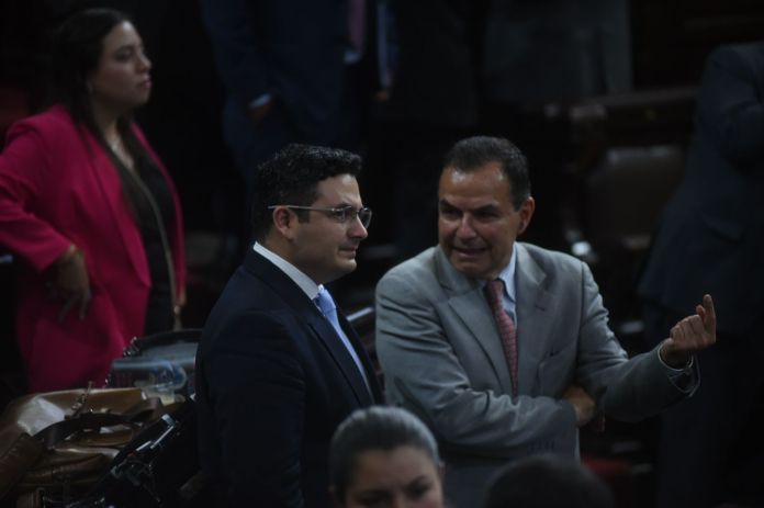 El presidente la comisión de Economía, Jorge Ayala (derecha) conversa con su colega Samuel Pérez por la asistencia en el Pleno para conocer la iniciativa de ley de Competencia. Foto: Fabricio Alonzo