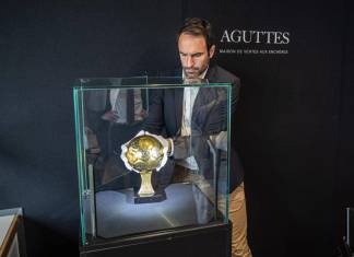 Francois Thierry de la casa de subastas Aguttes, instala en la vitrina el el Balón de Oro que ganó Diego Maradona. EFE/EPA/CHRISTOPHE PETIT TESSON