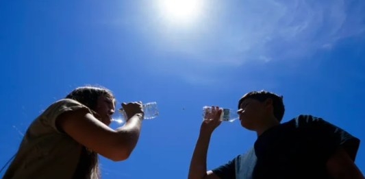 Personas tratan de protegerse del calor. Foto La Hora/AP