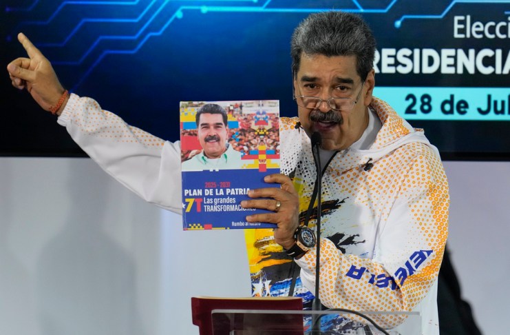 ARCHIVO - El presidente venezolano Nicolás Maduro sostiene un libro con su fotografía mientras habla en la Comisión Nacional Electoral, adonde llegó para formalizar su candidatura para postularse nuevamente a la presidencia en Caracas, Venezuela, el lunes 25 de marzo de 2024. Las elecciones están programadas para el 28 de julio. (AP Foto/Ariana Cubillos, Archivo)