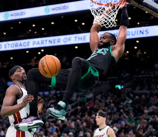 El base de los Celtics de Boston Jaylen Brown clava el balón frente al pívot del Heat de Miami Bam Adebayo en el juego 5 de la primera ronda de la postemporada el miércoles 1 de mayo del 2024. (AP Foto/Charles Krupa)