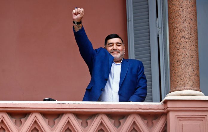 Diego Maradona saluda a la gente en la Casa Rosada, sede del gobierno de Argentina. (AP Foto/Marcos Brindicci)