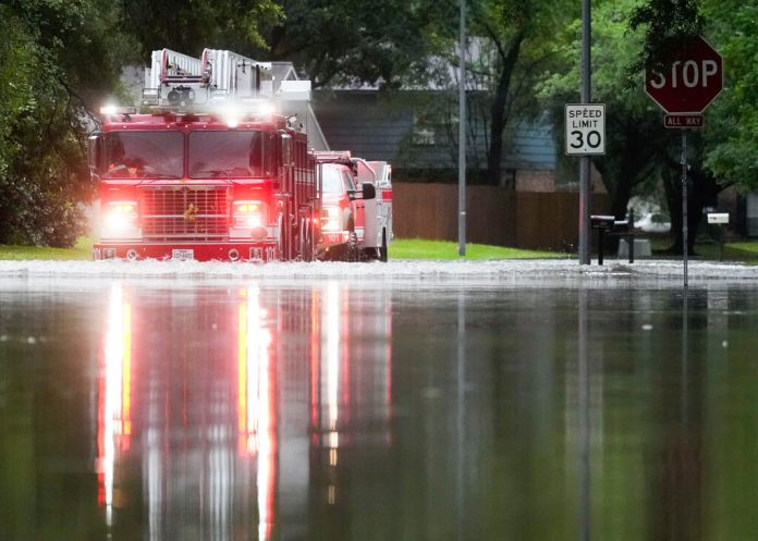 Un camión de bomberos de Houston atraviesa un camino inundado en North Woodland Hills. (Jason Fochtman/Houston Chronicle via AP)