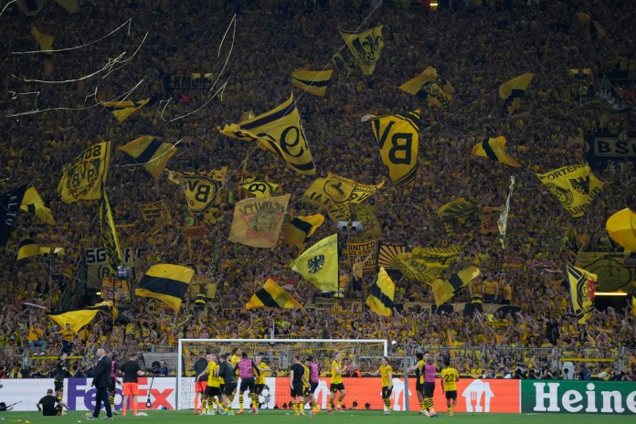 Los seguidores del Dortmund ondean banderas después del partido de ida de la semifinal de la Liga de Campeones entre el Borussia Dortmund y el Paris Saint-Germain en el estadio Signal-Iduna Park en Dortmund, Alemania, el miércoles 1 de mayo de 2024. (Foto AP/Matthias Schrader)
