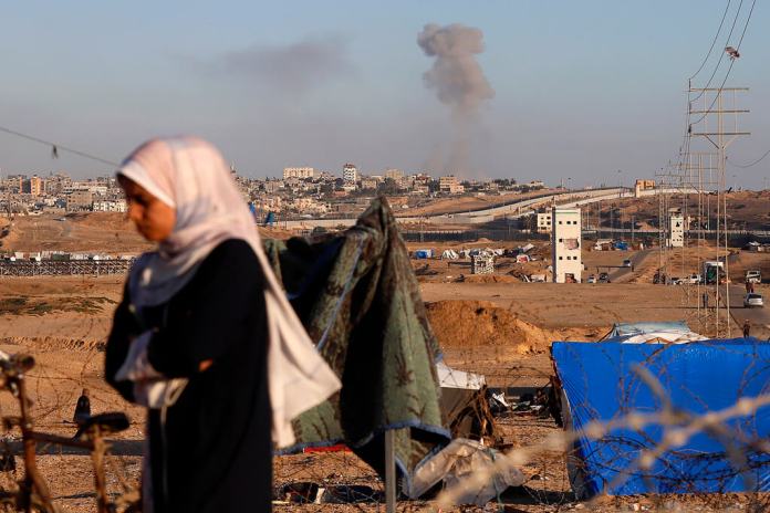 Una nube de humo señala el lugar donde se produjo un ataque aéreo israelí contra edificios cerca del muro que separa Egipto y Rafah, en el sur de Gaza. (AP Foto/Ramez Habboub)