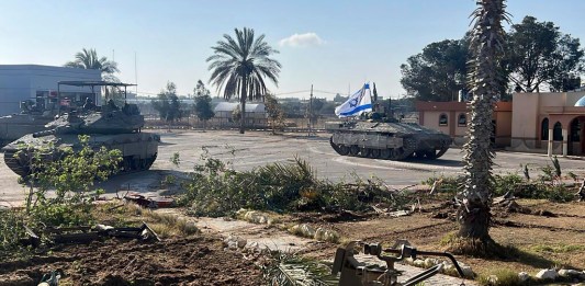 Un tanque con una bandera israelí entra al lado gazatí del paso fronterizo de Rafah. (Fuerzas de Defensa de Israel vía AP)