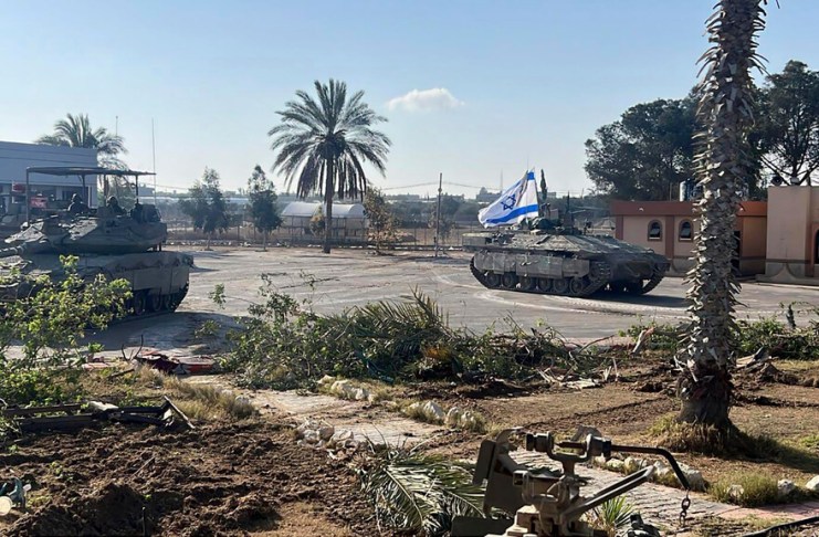 Un tanque con una bandera israelí entra al lado gazatí del paso fronterizo de Rafah. (Fuerzas de Defensa de Israel vía AP)