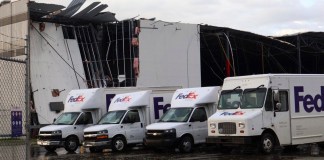 Camiones de FedEx se ven ante un centro dañado de FedEx tras el paso de un tornado en Portage, Michigan, el martes 7 de mayo de 2024. (Brad Devereaux/Kalamazoo Gazette via AP)