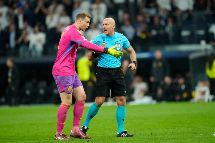 El portero del Bayern, Manuel Neuer, izquierda, habla con el árbitro Szymon Marciniak durante el partido de vuelta de la semifinal de la Liga de Campeones entre el Real Madrid y el Bayern de Múnich en el estadio Santiago Bernabéu de Madrid, España, el miércoles 8 de mayo de 2024. (Foto AP/José Bretón )