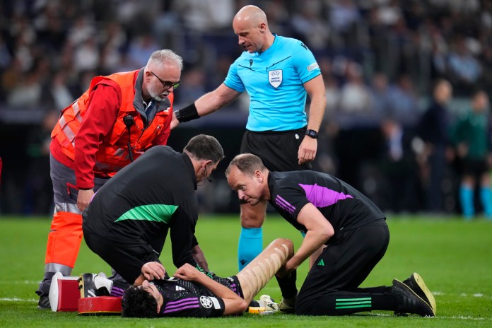 Aleksandar Pavlovic del Bayern recibe tratamiento del personal médico durante el partido de vuelta de la semifinal de la Liga de Campeones entre el Real Madrid y el Bayern de Múnich en el estadio Santiago Bernabéu de Madrid, España, el miércoles 8 de mayo de 2024. (Foto AP/Manu Fernández)