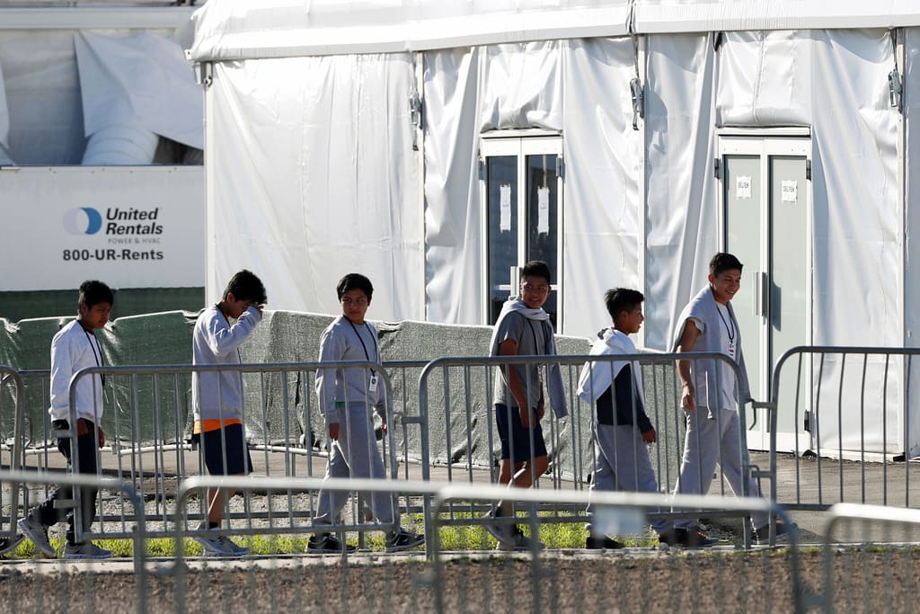 ARCHIVO - Esta fotografía del 19 de febrero de 2019 muestra a unos niños formados que entran a una carpa en un albergue temporal para niños migrantes que viajaron sin compañía de un adulto en Homestead, Florida. (AP Foto/Wilfredo Lee, Archivo)