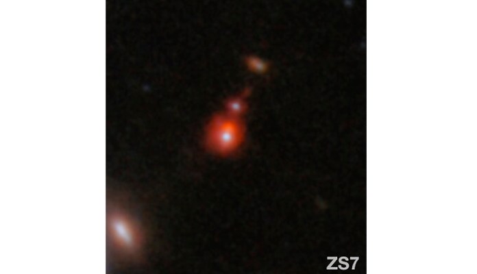 En esta imagen publicada por la NASA aparece el sistema de galaxias ZS7, que revela la emisión de hidrógeno ionizado en naranja, y la emisión de oxígeno doblemente ionizado en rojo oscuro. Foto: ESA/Webb, NASA vía AP