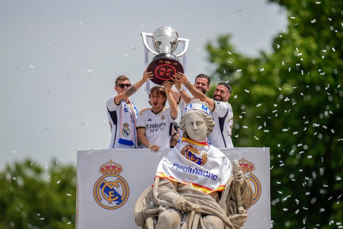 De izquierda a derecha, los jugadores del Real Madrid Toni Kroos, Luka Modric, Nacho y Dani Carvajal sostienen la copa de la Liga española durante la celebración del título en la plaza de Cibeles, en Madrid, el 12 de mayo de 2024. (AP Foto/Manu Fernández)