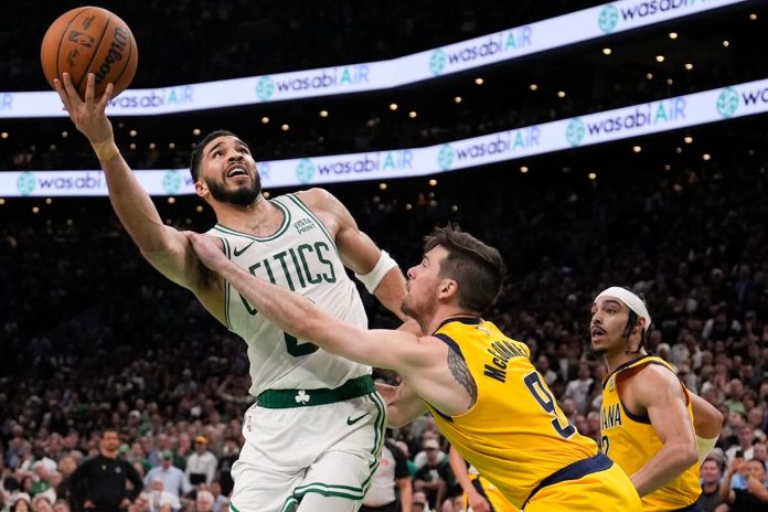El alero de los Celtics de Boston Jayson Tatum lanza el balón superando al base de los Pacers de Indiana martes 21 de mayo del 2024. (AP Foto/Charles Krupa)