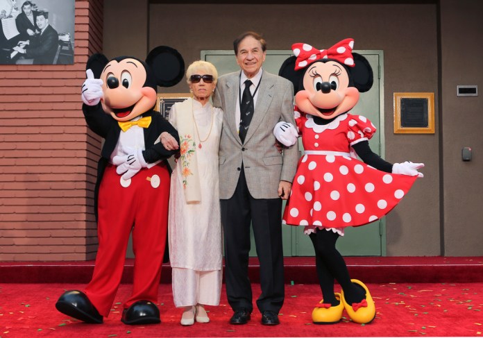 ARCHIVO - Mickey Mouse, de izquierda a derecha, Elizabeth Gluck, Richard M. Sherman y Minnie Mouse posan para una foto durante una ceremonia de homenaje a los hermanos Sherman en la que se renombró el Disney Studios Soundstage A durante el estreno mundial de 