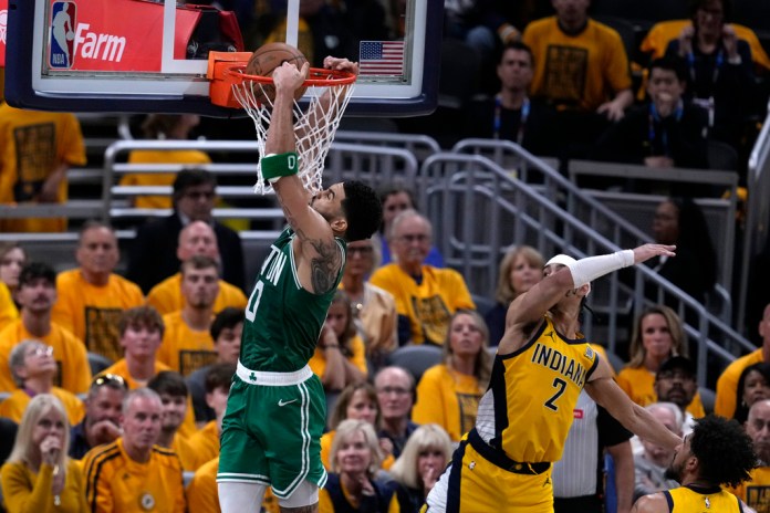 El delantero de los Boston Celtics, Jayson Tatum (0), encesta el balón frente al base de los Indiana Pacers, Andrew Nembhard (2), durante la segunda mitad del Juego 4 de las finales de baloncesto de la Conferencia Este de la NBA, el lunes 27 de mayo de 2024, en Indianápolis. (Foto AP/Darron Cummings)