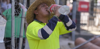 Un trabajador de carreteras hace un descanso para beber agua. (AP Foto/Paul White, Archivo)