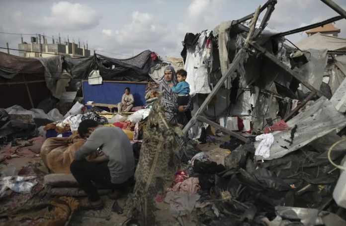 Palestinos desplazados inspeccionan sus tiendas destruidas por el bombardeo de Israel, adjuntas a una instalación de UNRWA al oeste de la ciudad de Rafah, Franja de Gaza, el 28 de mayo de 2024.