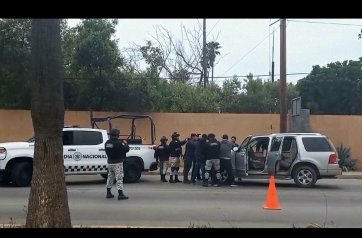 En esta imagen tomada de un video, fuerzas de seguridad mexicanas registran a hombres en un puesto de control, el jueves 2 de mayo de 2024, en Ensenada, México. (AP Foto)